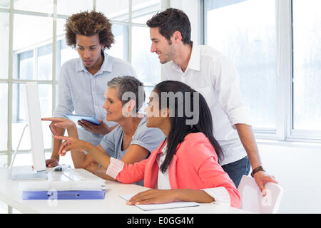 Workers looking at a presentation on the computer Stock Photo