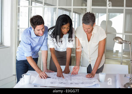 Three architects looking at blueprints Stock Photo