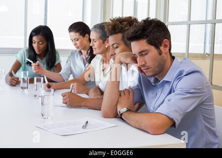 Casual businessman falling asleep during meeting Stock Photo