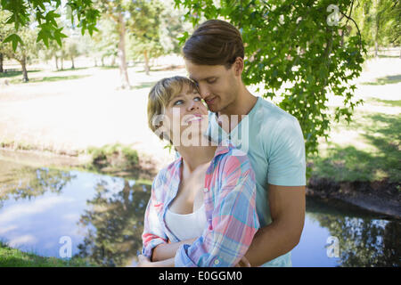 Affectionate young couple standing together in the park Stock Photo