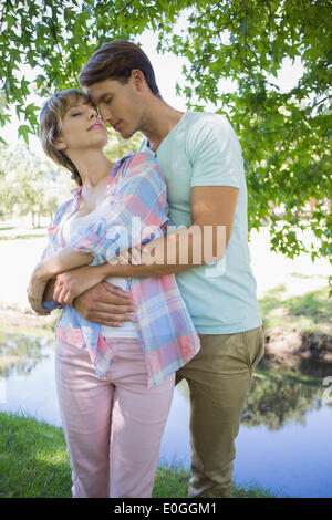 Affectionate young couple standing together in the park Stock Photo