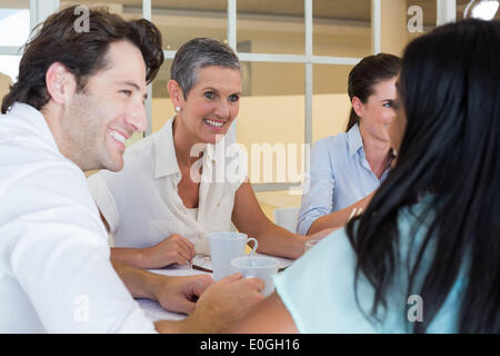Business people smile and chat while enjoying hot drinks Stock Photo