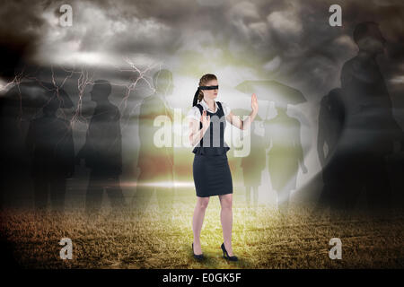 Composite image of redhead businesswoman in a blindfold Stock Photo