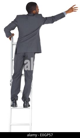 Businessman standing on ladder Stock Photo