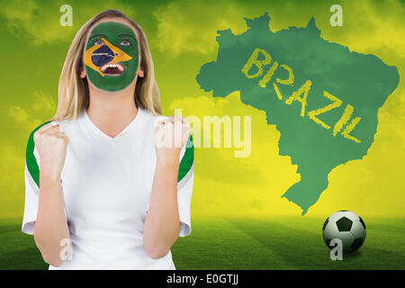 Excited brasil fan in face paint cheering Stock Photo