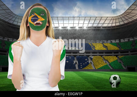 Excited brasil fan in face paint cheering Stock Photo