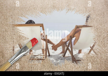 Composite image of couple on the beach in deck chairs Stock Photo