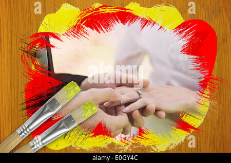 Composite image of groom placing ring on brides finger Stock Photo