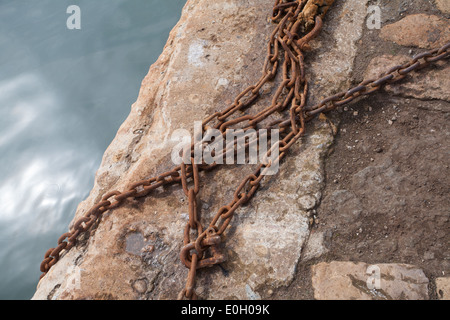 rusty chains on the quayside at Beadnell harbour Northumberland UK Stock Photo