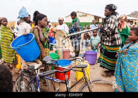 Women at the water well, pump in front of a school in the village of Machinga Peheriya, Malawi, Africa Stock Photo