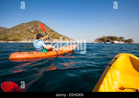 A man paddling in a canoe at Cape Maclear, Otters Point, Lake Malawi, Africa Stock Photo