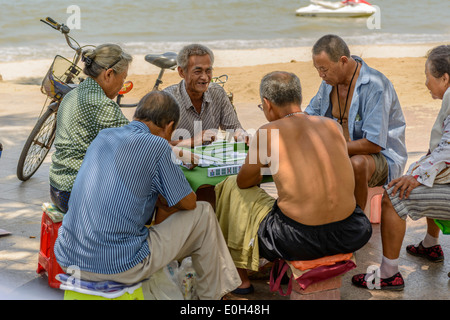 Some old people playing mahjong on the summer beach. Stock Photo