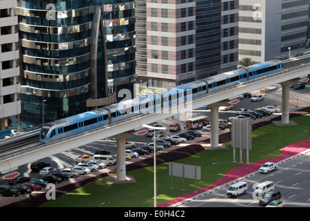 A train on the Red line of the Dubai metro travels past the tall buildings and the traffic of Sheikh Zayed Road in Dubai.