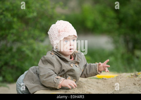 girl with Down syndrome playing in the sandbox Stock Photo