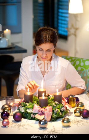 Mid adult woman lighting candles on an Advent wreath, Styria, Austria Stock Photo