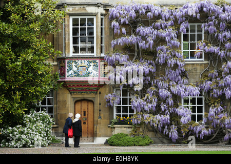 STUDENTS WALKING PAST THE WISTERIA  ON THE MASTER'S LODGE AT CHRIST'S COLLEGE CAMBRIDGE Stock Photo