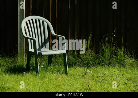 Solitary green plastic garden chair Stock Photo