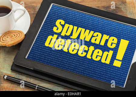 spyware detected alert on a digital tablet with a cup of coffee Stock Photo