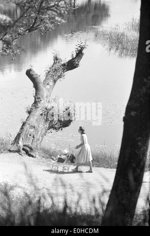 This image captures a summer day in 1963 in the Old Town (Gamlebyen) of Fredrikstad, Norway. It depicts a scene from a stroller tour, showcasing the town's historic architecture and charming streets. Stock Photo