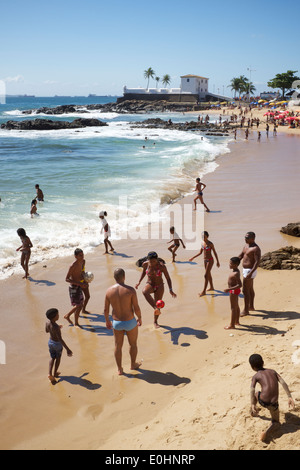 SALVADOR, BRAZIL - OCTOBER 13, 2013: Locals relax on Porto da Barra beach near the Fort Santa Maria. Stock Photo