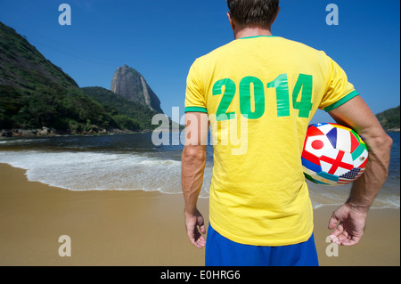 Brazilian football player standing with international soccer ball in 2014 shirt at Sugarloaf Pao de Acucar Rio de Janeiro Brazil Stock Photo
