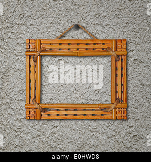 Bamboo frame on gray stucco concrete wall. Closeup. Stock Photo