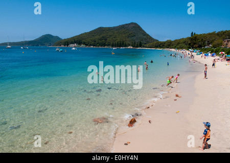 Holiday makers cool off in the clear blue sea at Shoal Bay, Port Stephens, New South Wales, Australia. Stock Photo