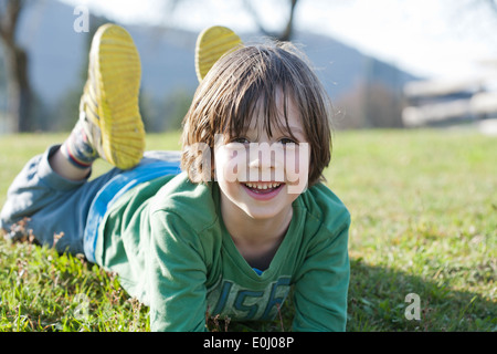 Boy lying on lawn. Stock Photo