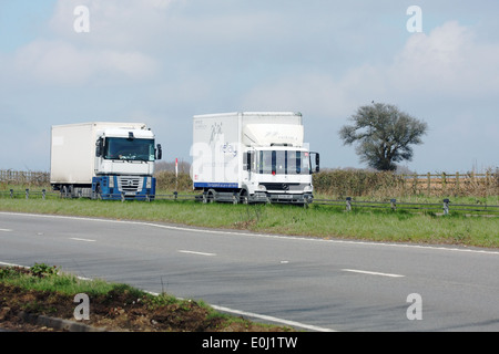 Two trucks traveling along the A417 dual carriageway in The Coswolds, England Stock Photo