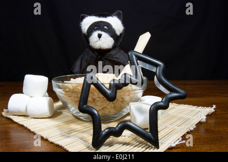 Cute halloween bear dressed as a vampire bat making bat shaped puffed rice cereal cookie treats Stock Photo