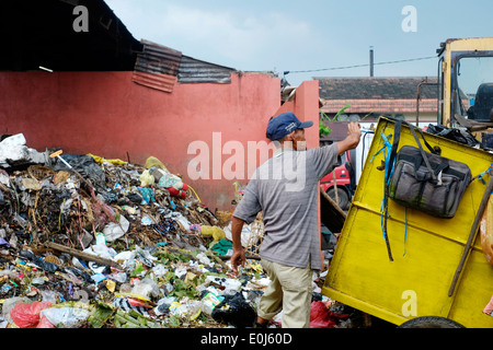 local man working amongst a huge pile of fetid refuse on a public dump in malang java indonesia Stock Photo