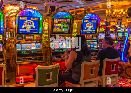 A couple playing the slot machines in the Casino of the Wynn Hotel Las Vegas Nevada USA Stock Photo