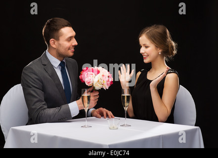 smiling man giving flower bouquet to woman Stock Photo