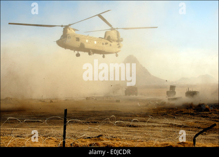 A Chinook helicopter passes over an International Security Assistance Forces convoy in order to drop soldiers off outside Comba Stock Photo