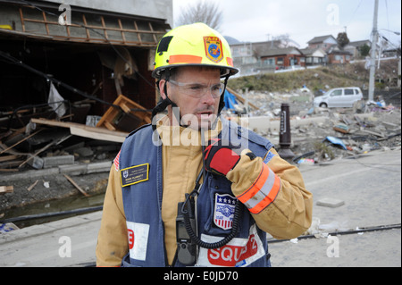 Mark Plunkett, a member of the Fairfax County Search and Rescue team provides an update for team members via radio as they look Stock Photo