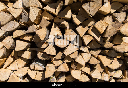 Pile of chopped fire wood prepared for winter in the sun Stock Photo