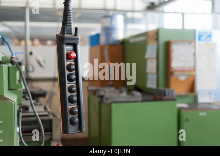 Emergency Stop button on an industrial machine at a repair shop Stock Photo