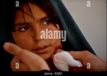 A young Afghan girl receives medical attention from a Medical Coreman in the Village of Safarak, Farah Province, Afghanistan Ma Stock Photo