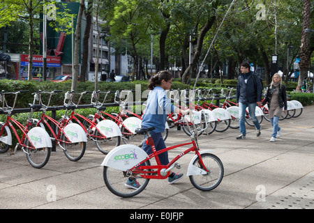 Woman renting a bike from Ecobici along Paseo De La Reforma on Car free Sunday Stock Photo