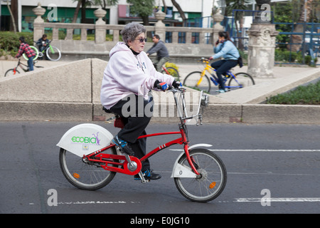 Mature woman riding an Ecobici along Paseo De La Reforma on Car free Sunday Stock Photo