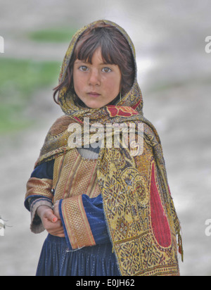 An Afghan girl looks on as paratroopers from 3rd platoon, Apache Company patrol in the village of Gorchek during Operation Naru Stock Photo