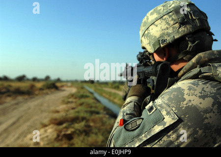A U.S. Soldier, assigned to 1-150th Company, Bravo Troop, 3rd Platoon, pulls security as vehicles approach the closed off road Stock Photo