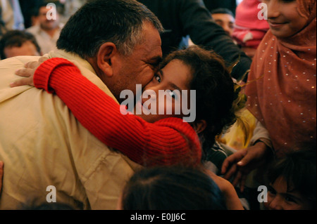 An Iraqi man who was released kisses his child for the first time since he was arrested. He was released as a member of the Lio Stock Photo