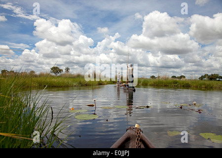 tourists on a traditional mokoro boat in the Okavango Delta, Botswana, Africa Stock Photo