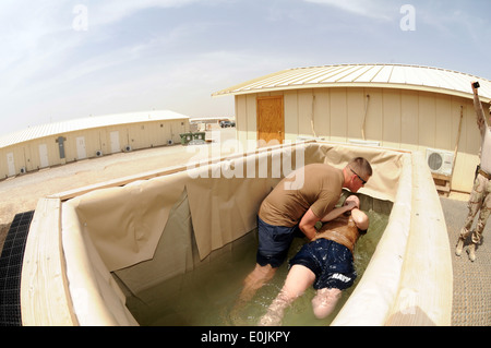 Builder 1st Class Ina M. Baca, from Eustis, Fla., assigned to Naval Mobile Construction Battalion 11, is submerged in water by Stock Photo