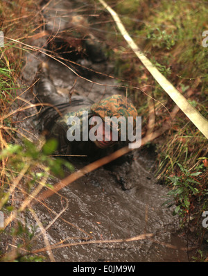 A Marine with 5th Battalion, 10th Marine Regiment, 2nd Marine Division, low crawls through the final portions of the Battle Ski Stock Photo