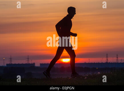 Cowpen Bewley Woodland Park, Billingham, UK. 15th May, 2014. Jogger at sunrise on a glorious Thursday morning. Temperatures continue to rise across the UK with Friday forecast to be the warmest day of the year so far. Credit:  ALANDAWSONPHOTOGRAPHY/Alamy Live News Stock Photo