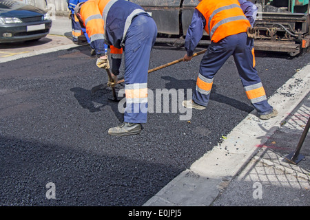 Workers on Asphalting paver machine during Road street repairing works Stock Photo