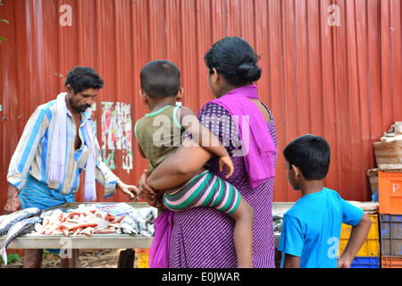 Woman with two kids buys fish from fish monger Stock Photo