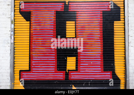 A giant letter H painted on a roller shutter in Middlesex Street, London, by street artist Ben Eine. Stock Photo